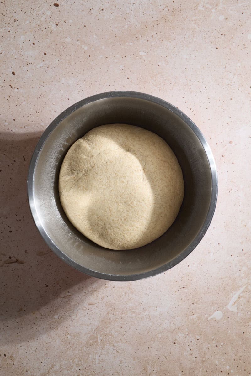 Puffy dough in a bowl after the first rise.