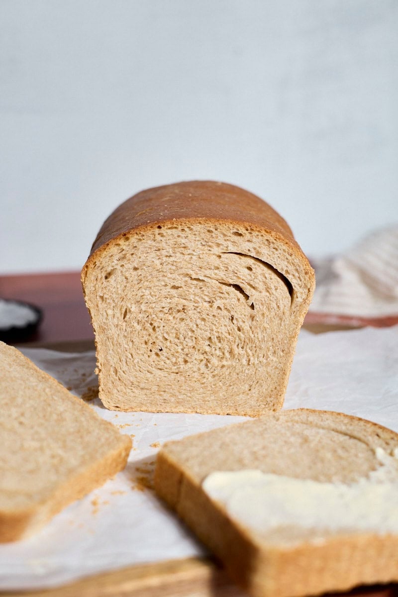 Side view of a sliced loaf of Sourdough Discard Whole Wheat Sandwich Bread.