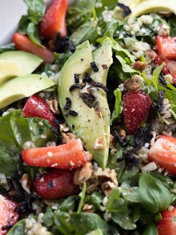 Spinach and Arugula Salad topped with strawberries and avocado.