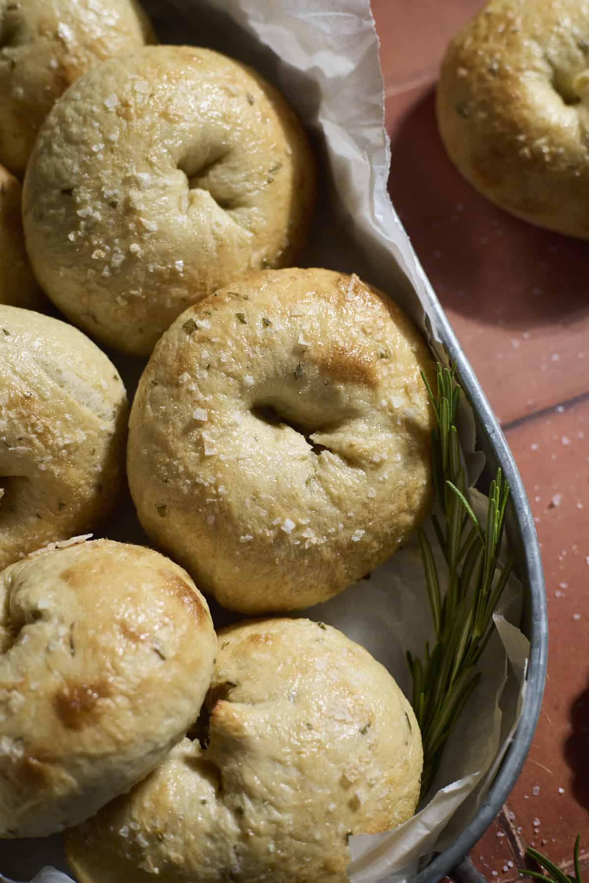 Sourdough Discard Rosemary Salt Bagels in a round metal tray.