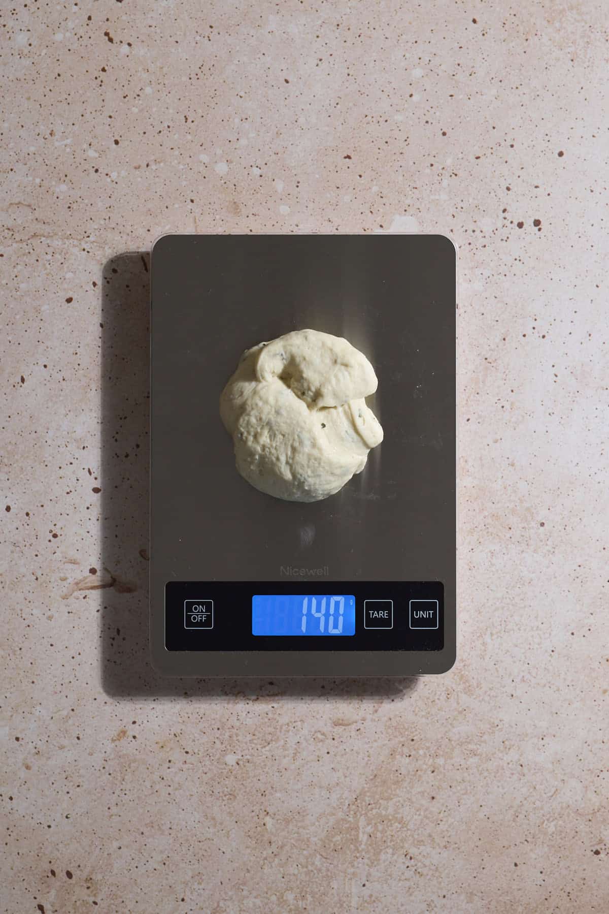 Dough being weighed on a kitchen scale.