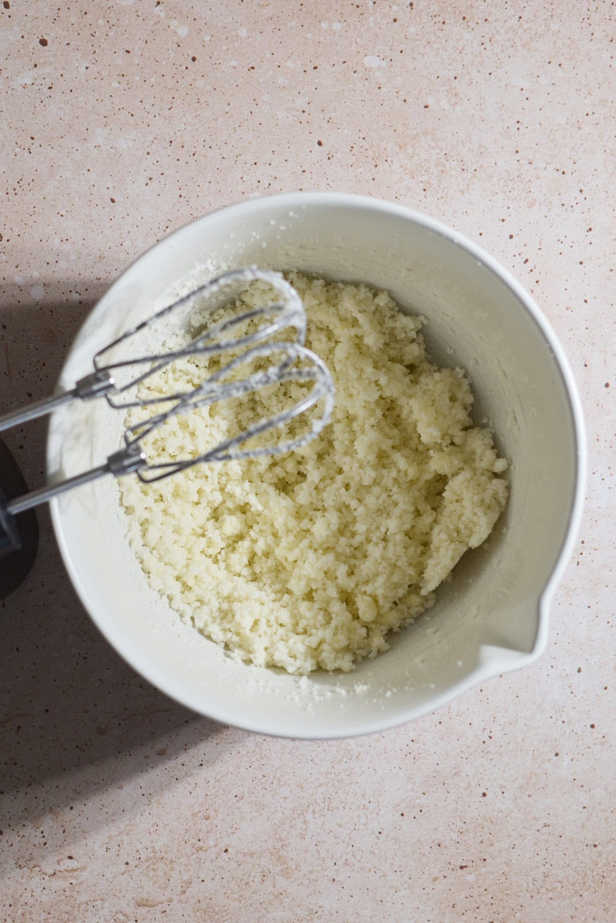 Butter and sugar creamed in a white bowl.