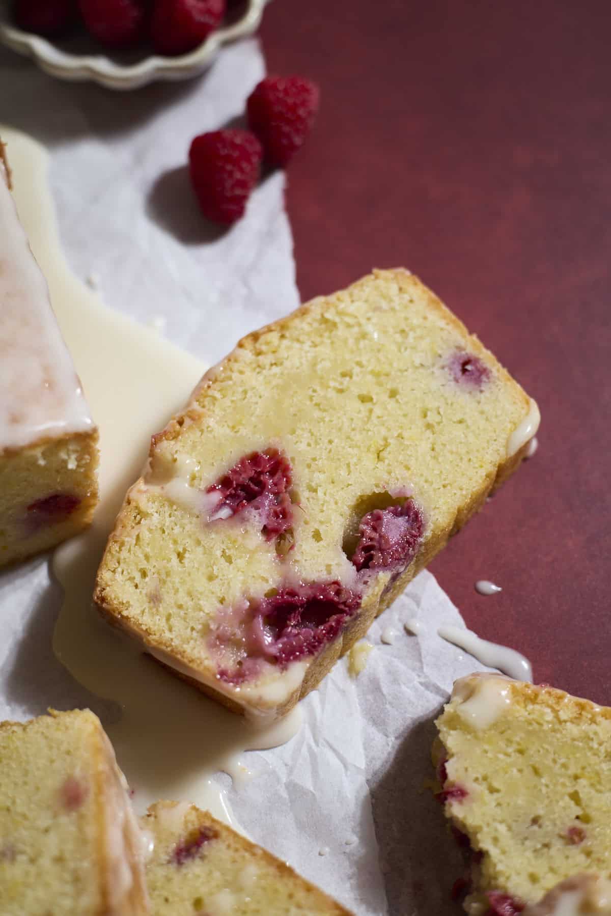 A slice of Sourdough Lemon Raspberry Loaf Cake.