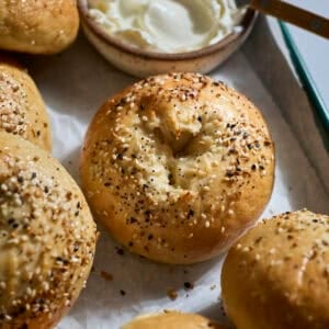Sourdough Discard Protein Bagels on a green tray with cream cheese.