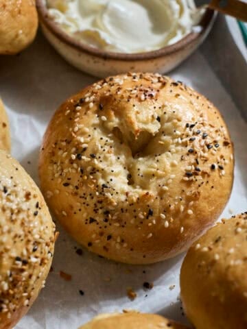 Sourdough Discard Protein Bagels on a green tray with cream cheese.