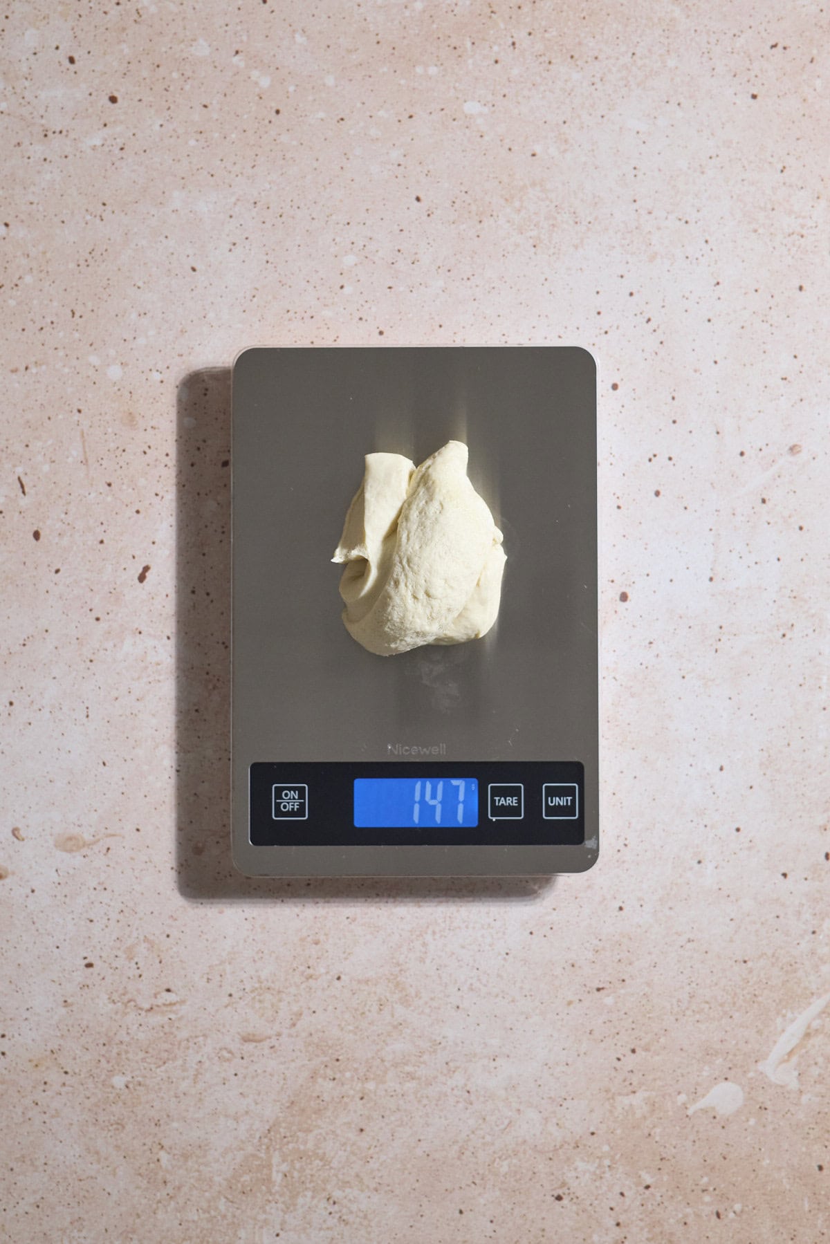 Dough being weighed on a kitchen scale.