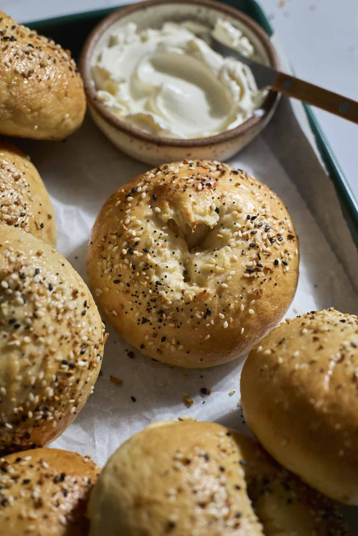 Sourdough Discard Protein Bagels on a green tray with cream cheese.