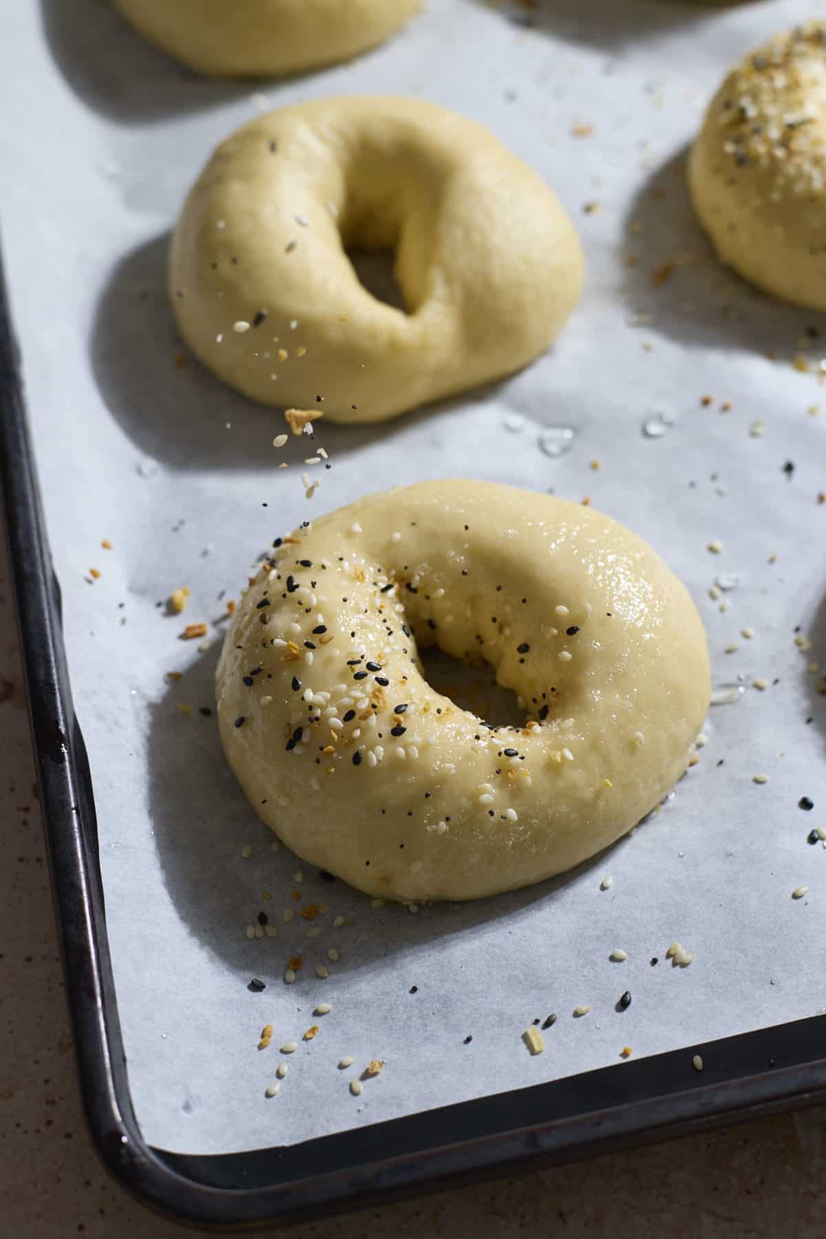 Toppings being added to the bagels.