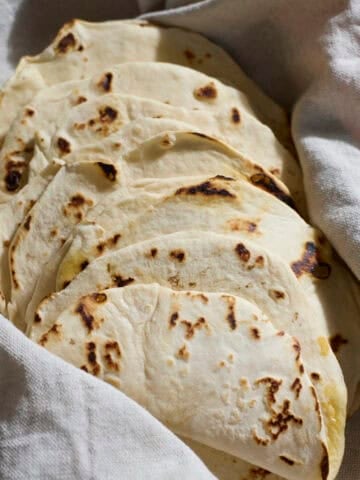 Sourdough Discard Tortillas wrapped in a kitchen towel.