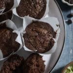 Chocolate Sourdough Zucchini Muffins on a white platter.
