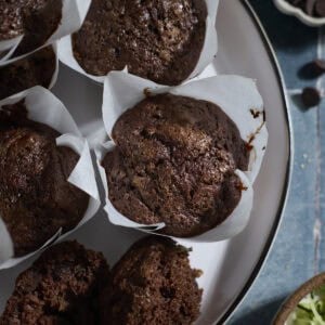 Chocolate Sourdough Zucchini Muffins on a white platter.
