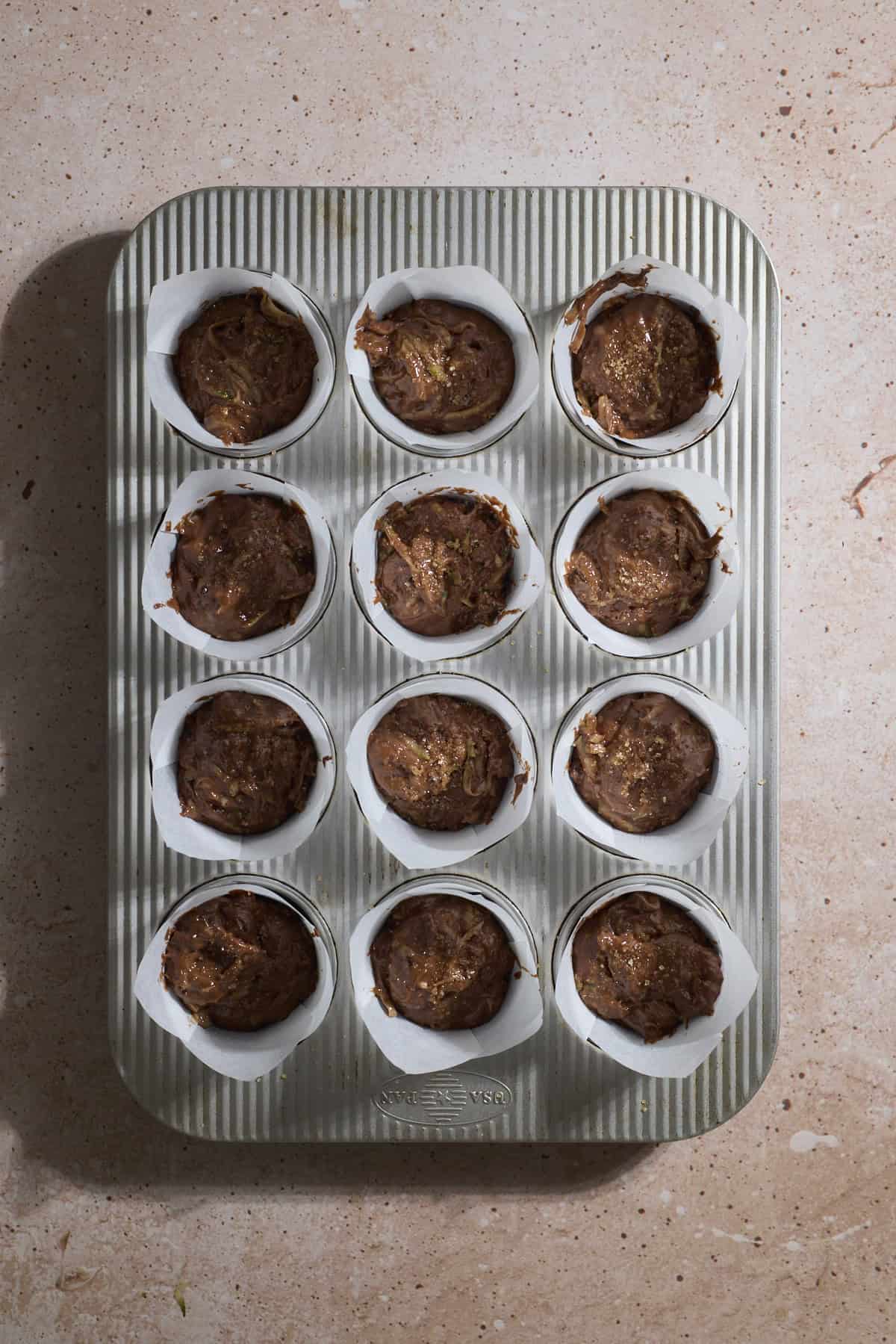 Muffin batter in the muffin pan.