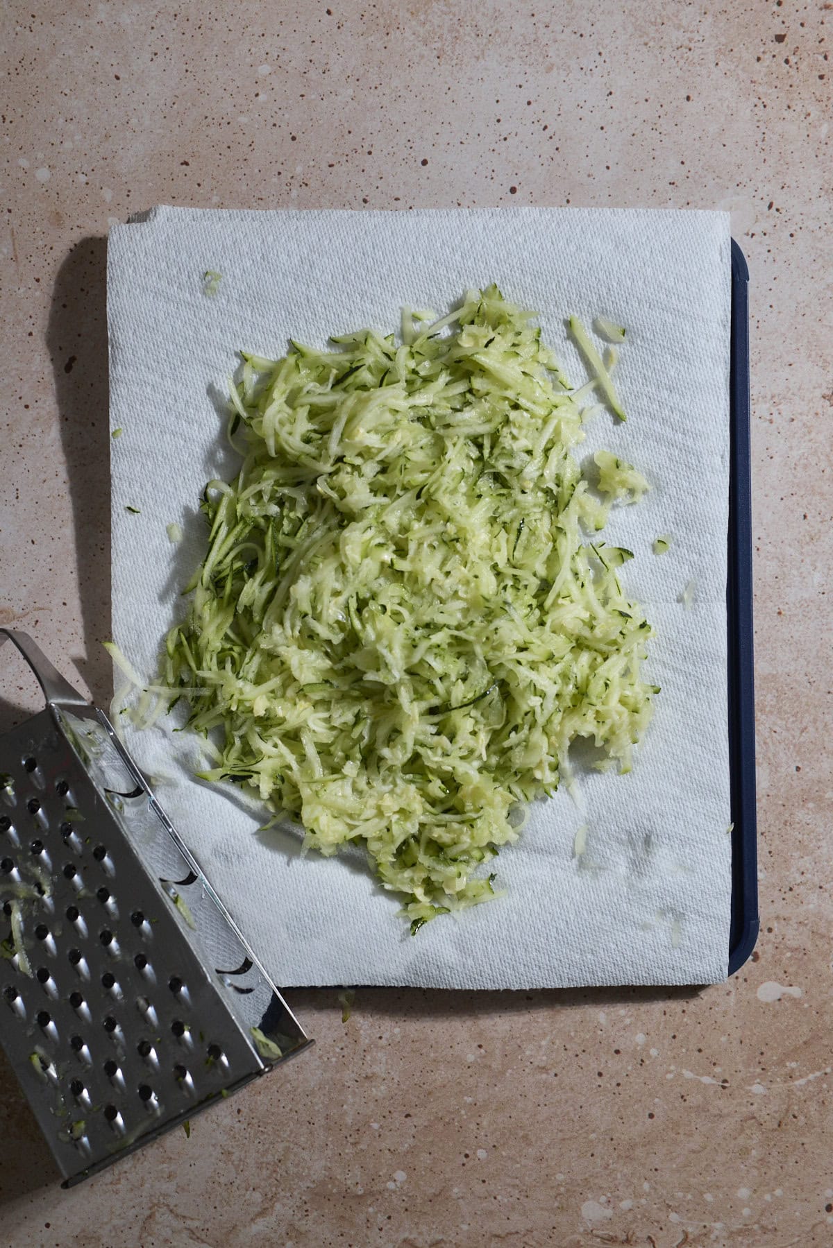 Shredded zucchini on paper towels.