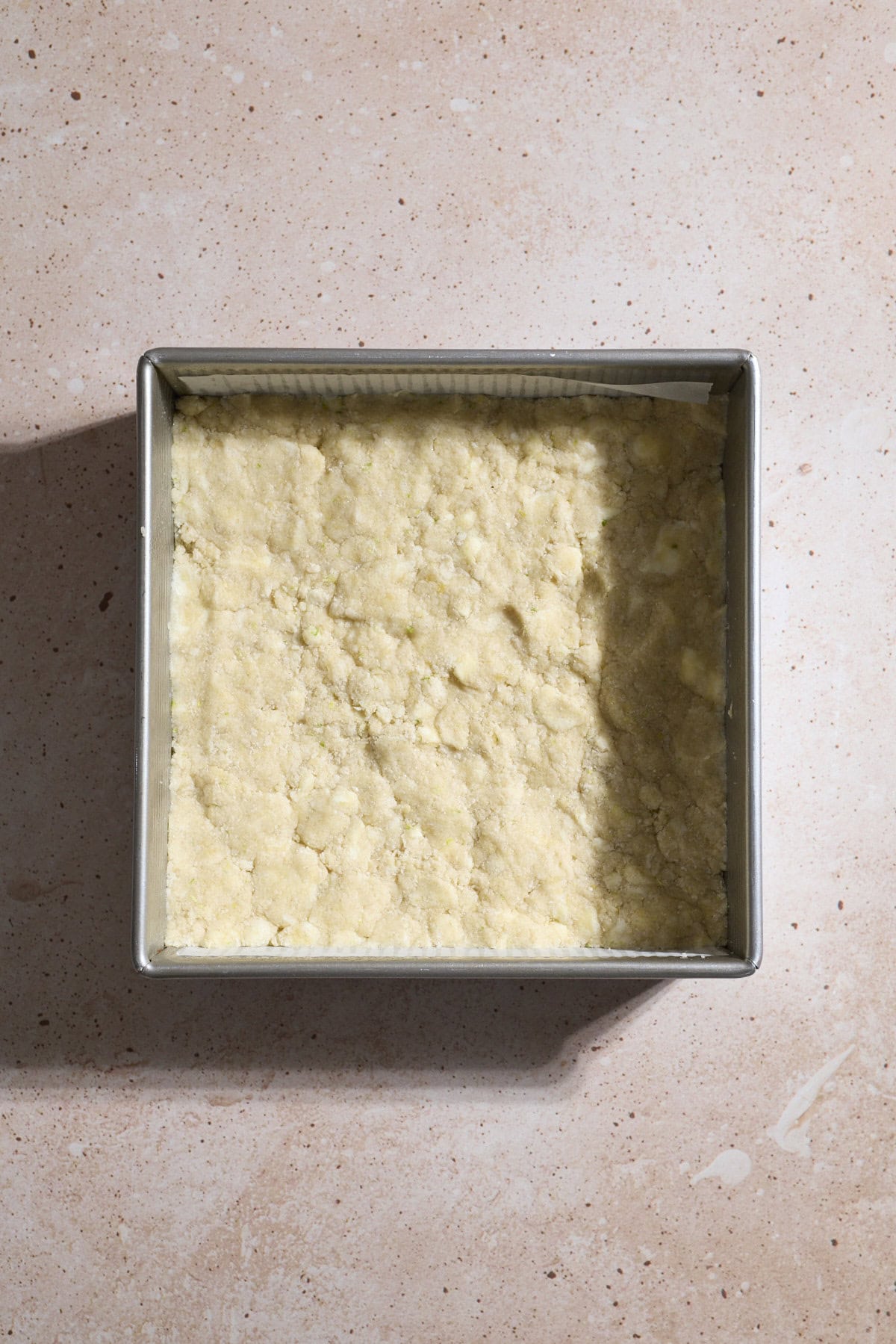 Dough pressed into the base of the baking pan.