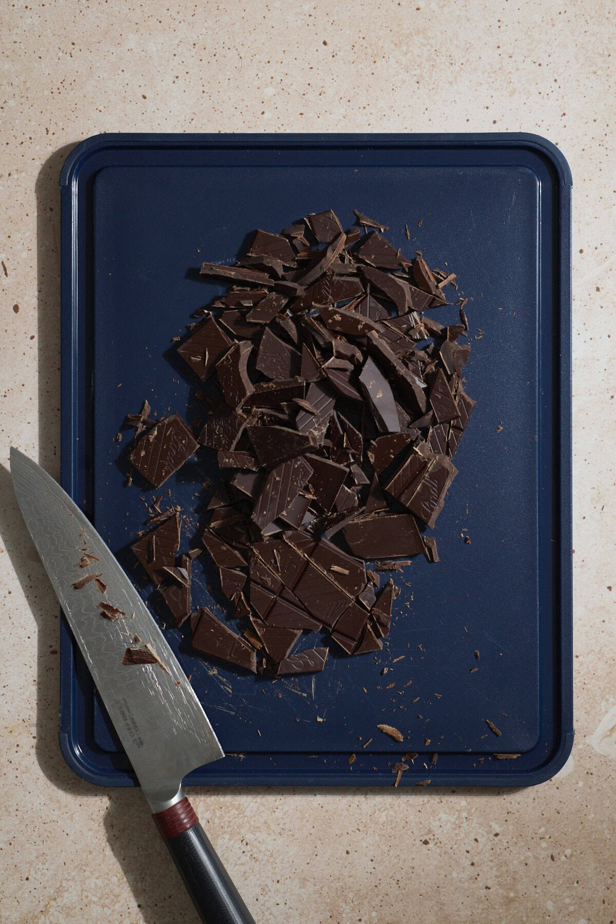 Chopped chocolate on a cutting board.