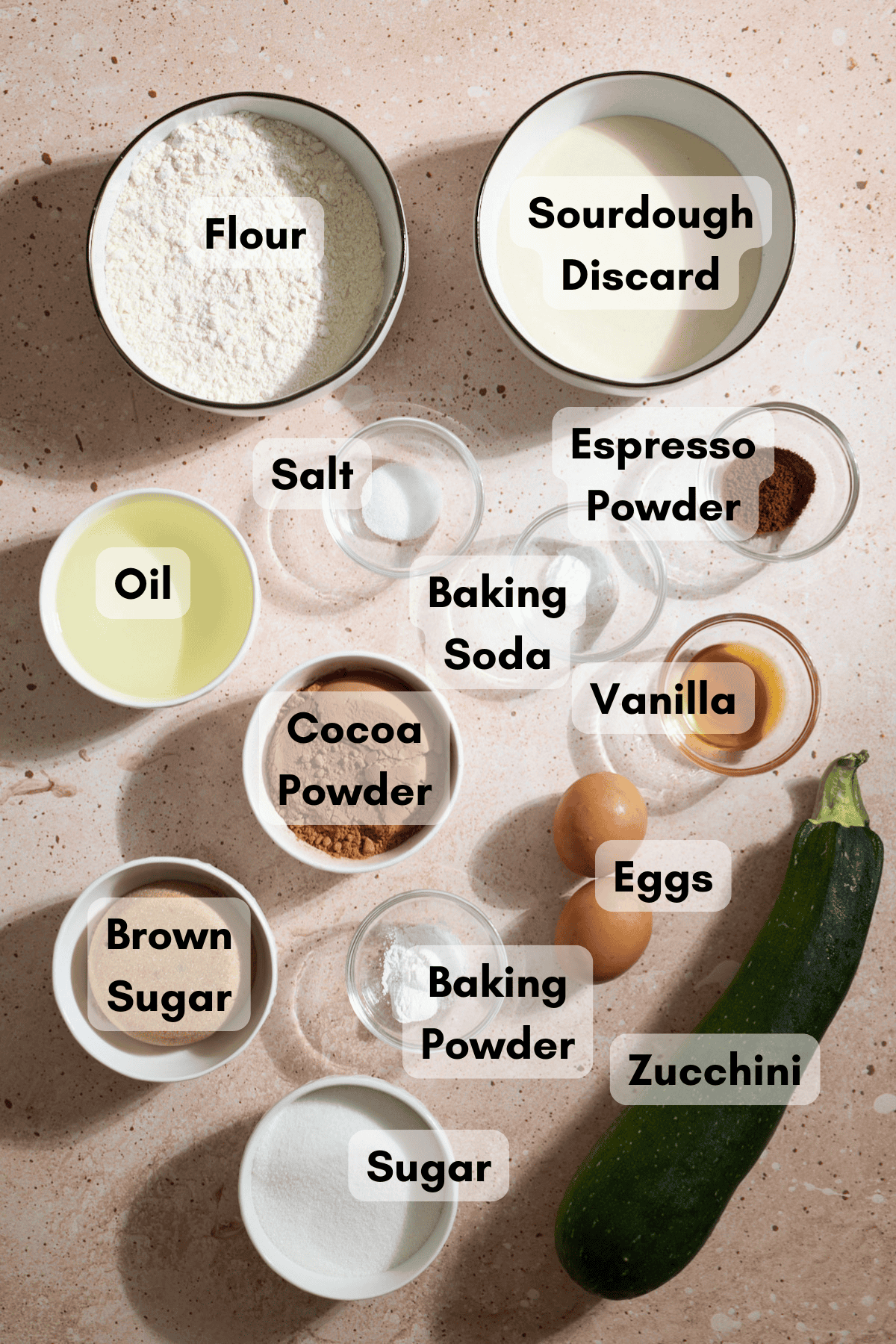 Ingredients for Sourdough Chocolate Zucchini Cake in small bowls.