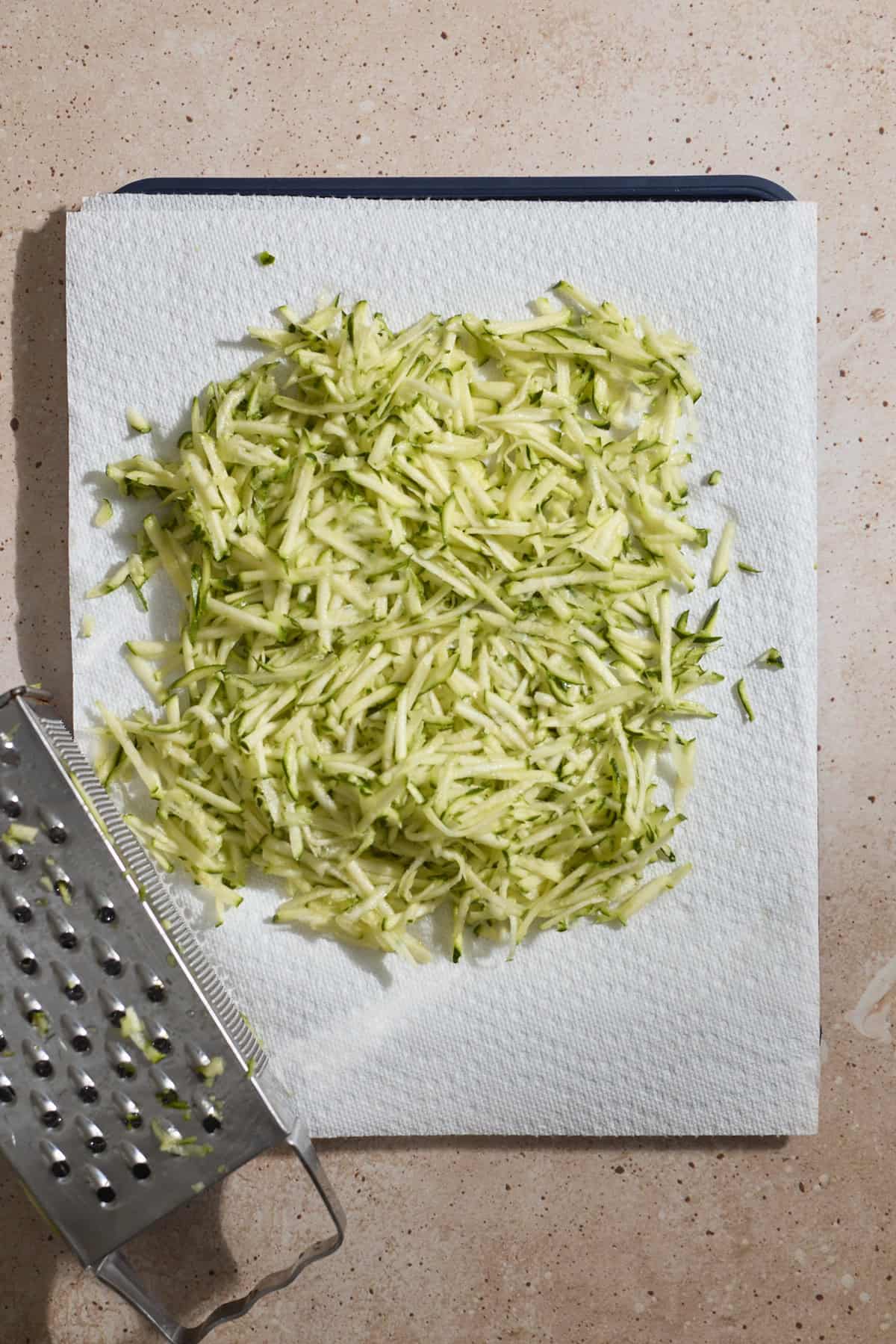Zucchini shredded onto paper towels.