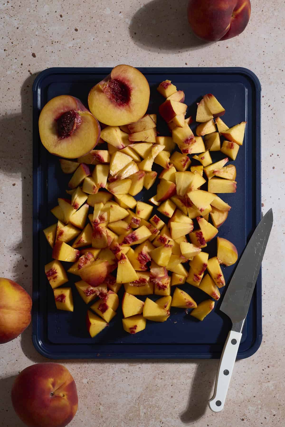 Chopped peaches on a cutting board.