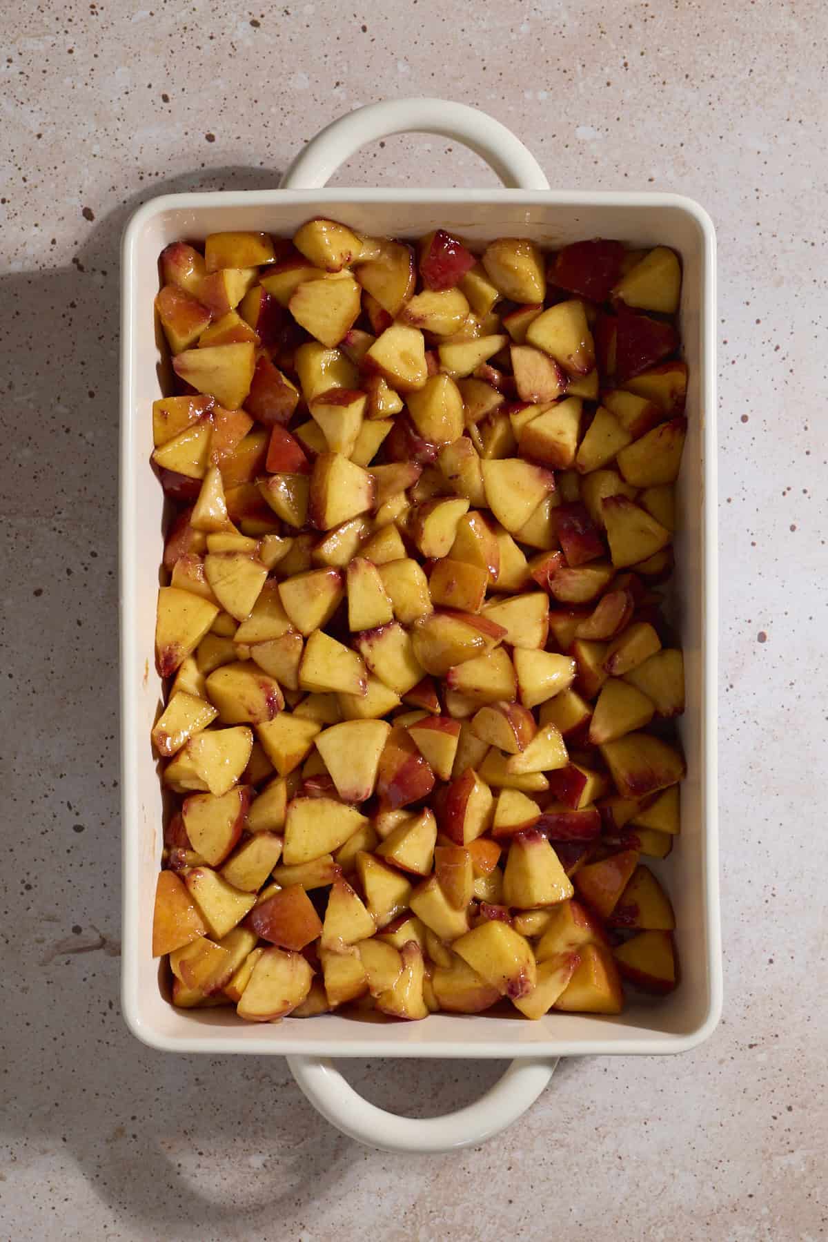 Peaches spread in a baking dish.