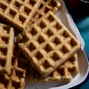 A stack of Sourdough Zucchini Waffles on a white tray.