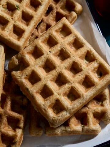 A stack of Sourdough Zucchini Waffles on a white tray.