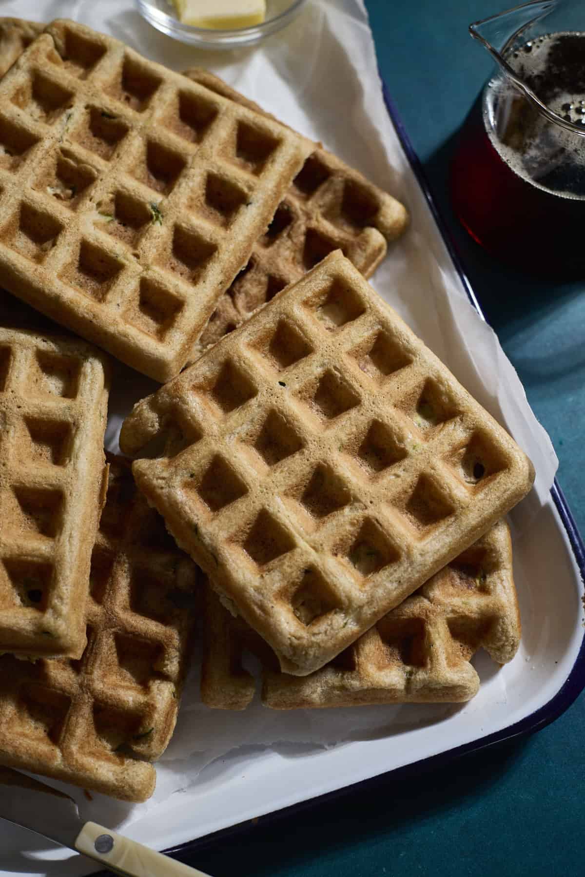 A stack of Sourdough Zucchini Waffles on a white tray.