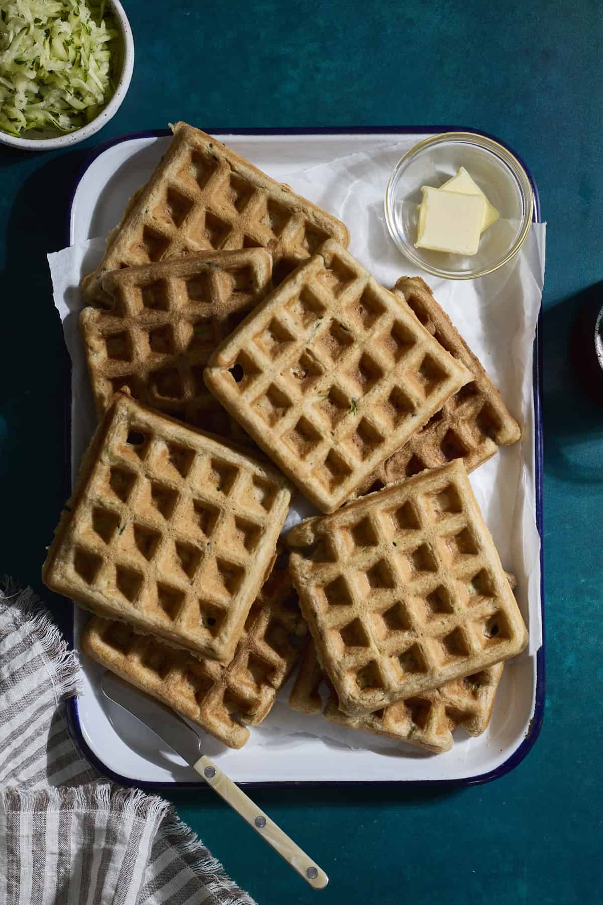 A stack of Sourdough Zucchini Waffles on a white tray.