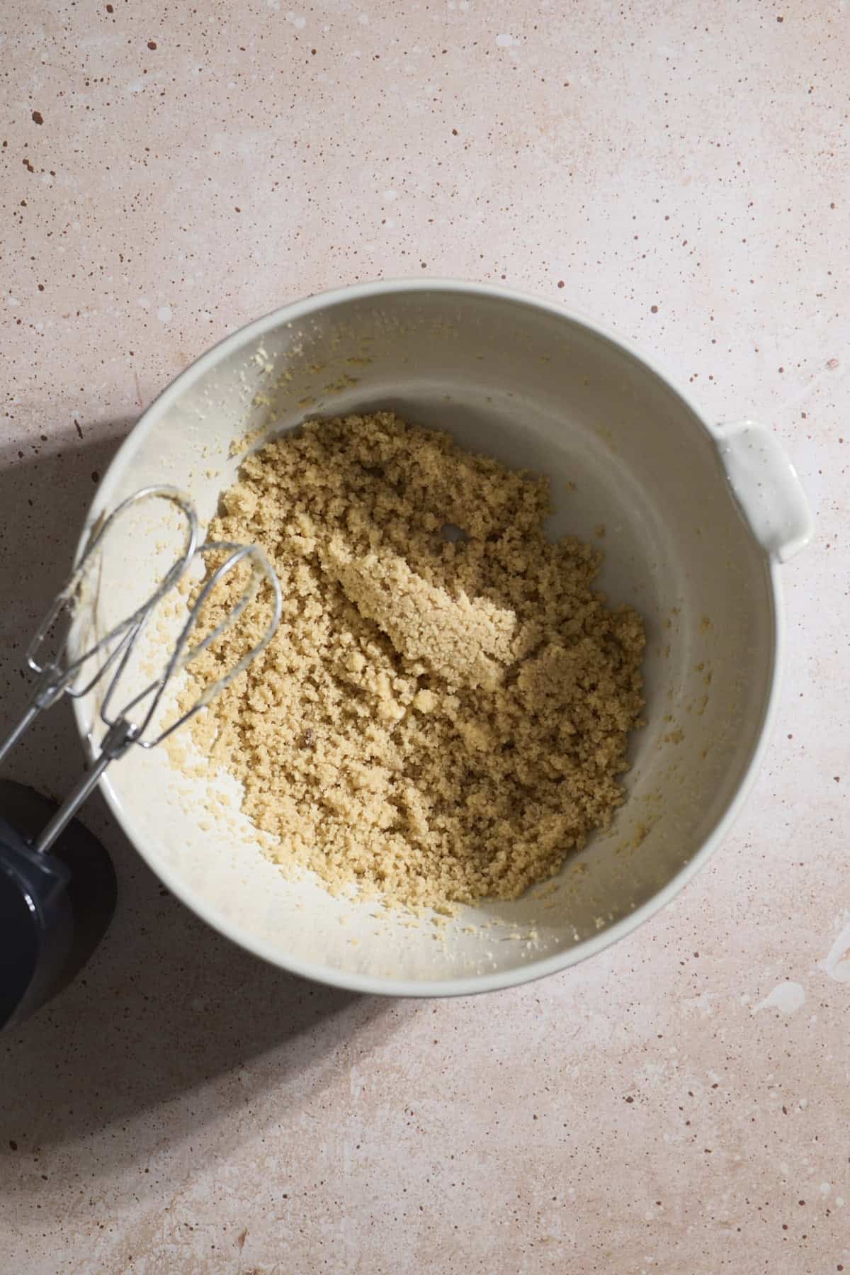 Butter and sugars creamed together in a mixing bowl.
