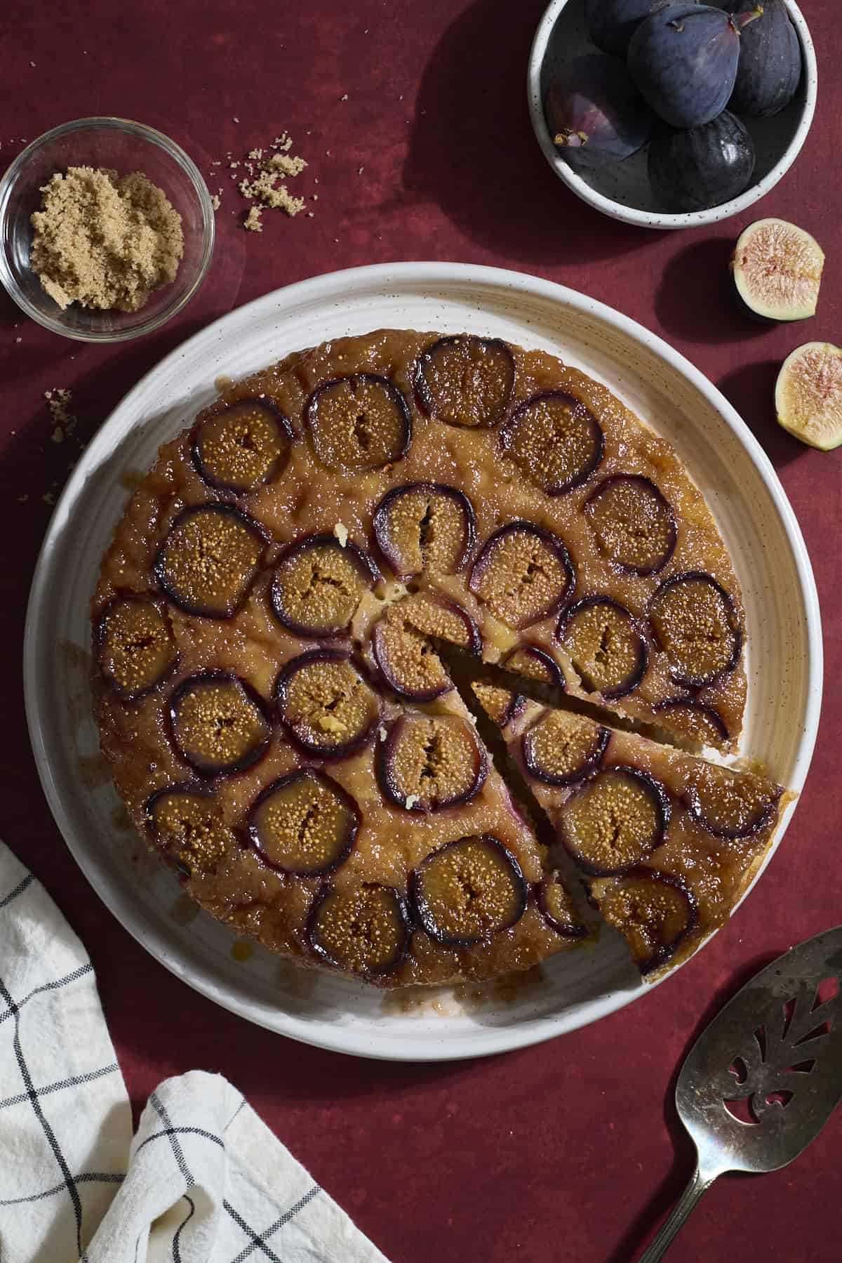 Sourdough Fig Cake on a white platter with a slice cut out.