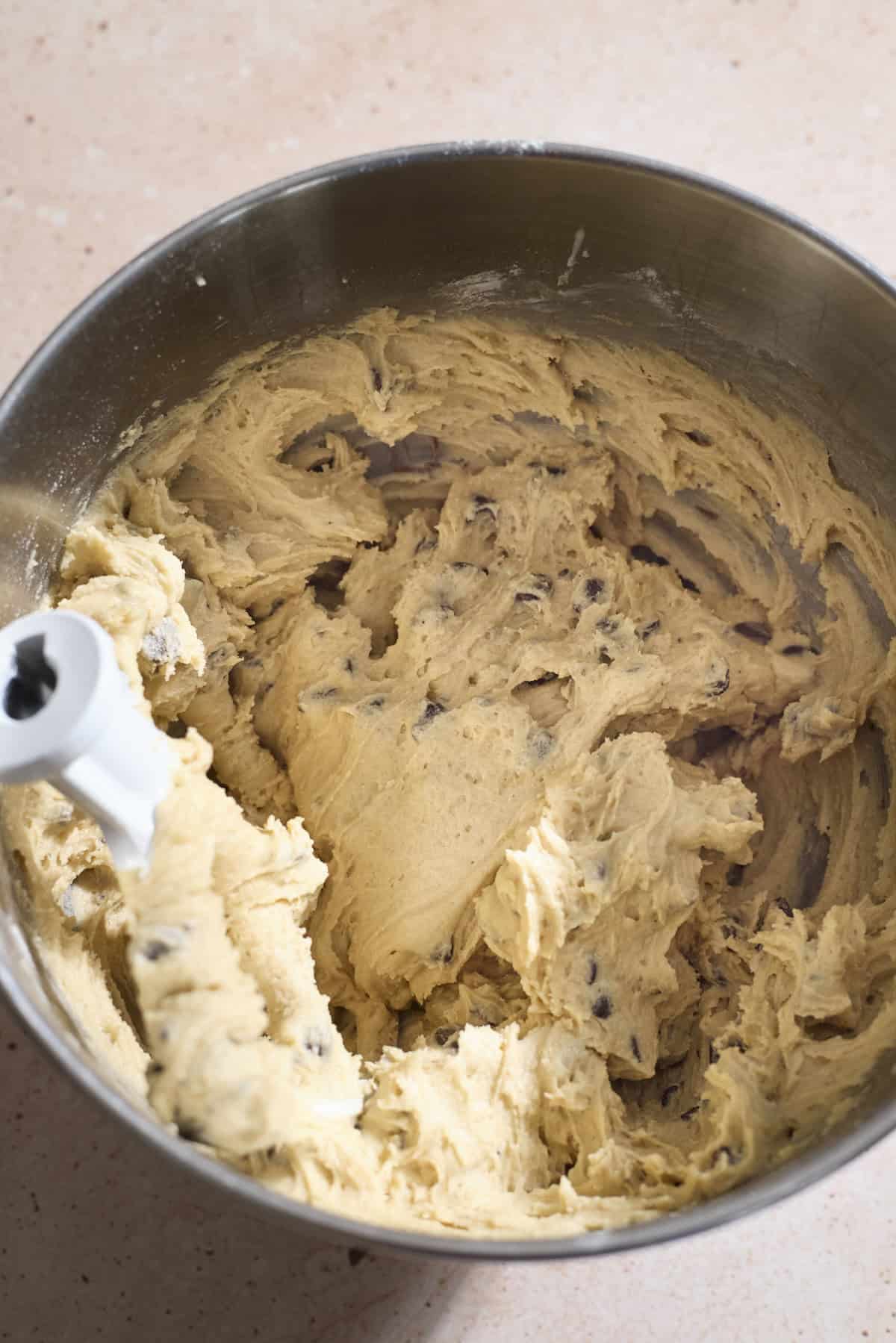 Cookie dough in the bowl of a stand mixer.