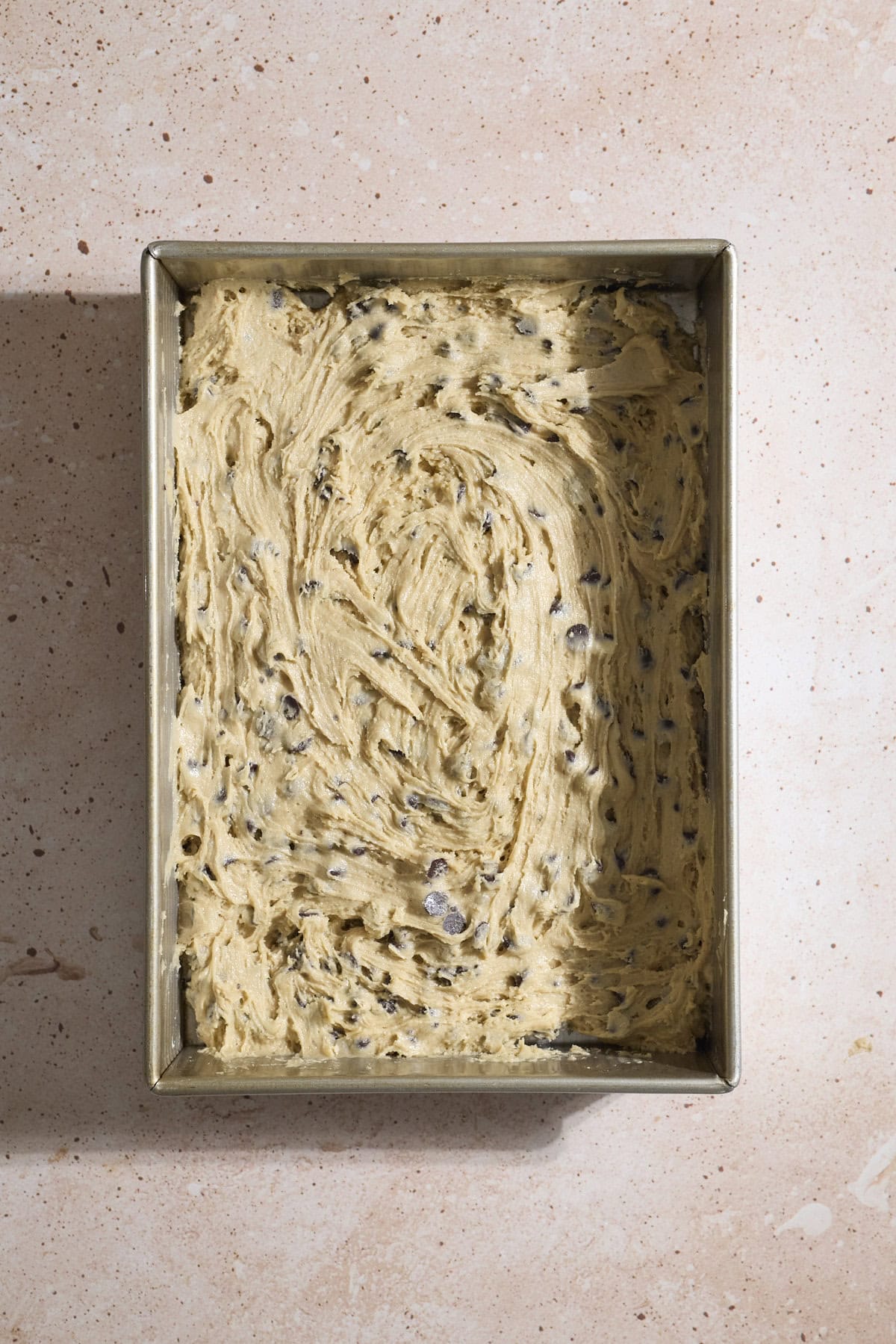 Cookie dough spread into a 9x13-inch baking pan.
