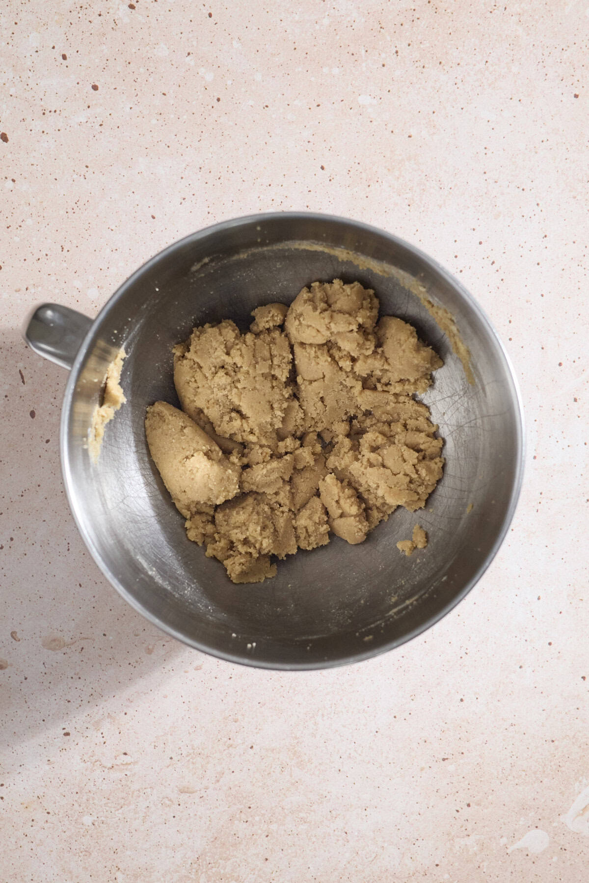 Butter and sugars mixed together in the bowl of a stand mixer.