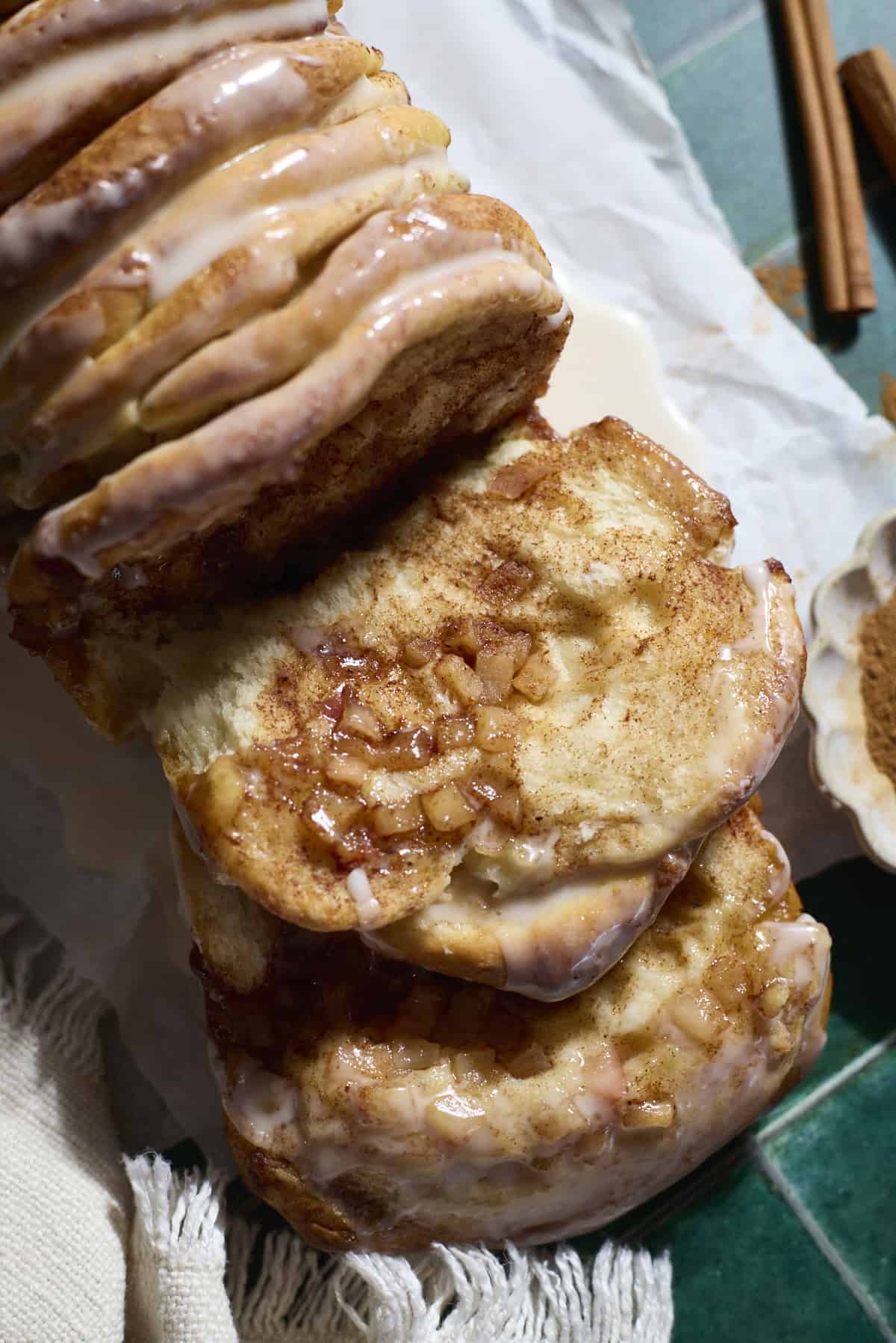 A piece of Sourdough Discard Apple Pull Apart Bread laying next to the loaf.