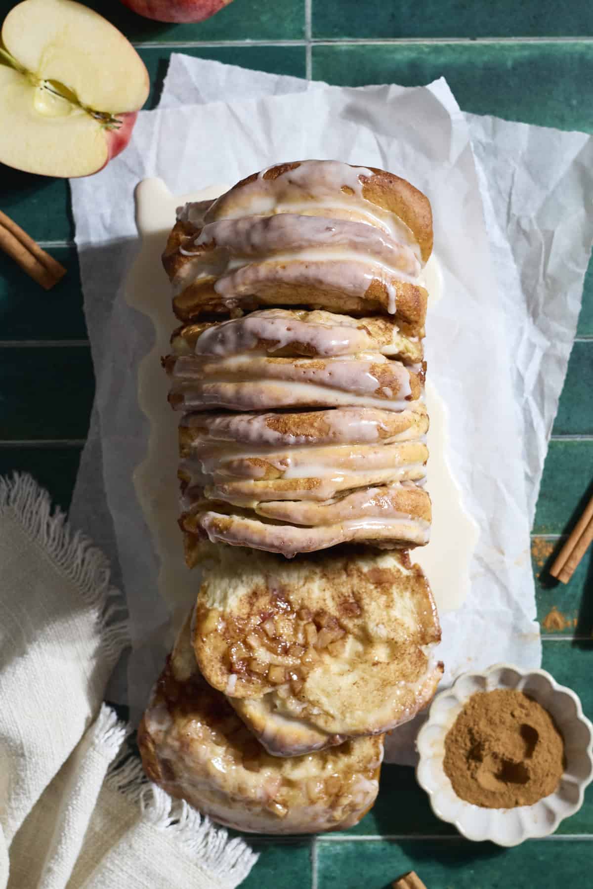 A piece of Sourdough Discard Apple Pull Apart Bread laying next to the loaf.