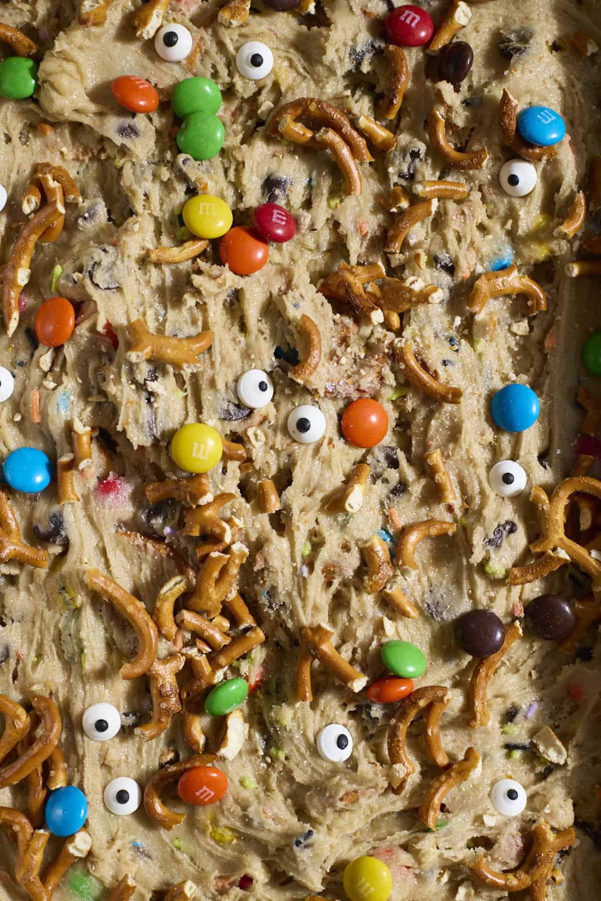 Pretzels, M&Ms and googly eyes on top of the cookie batter.