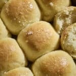 Sourdough Discard Potato Dinner Rolls topped with melted butter and flaky sea salt.