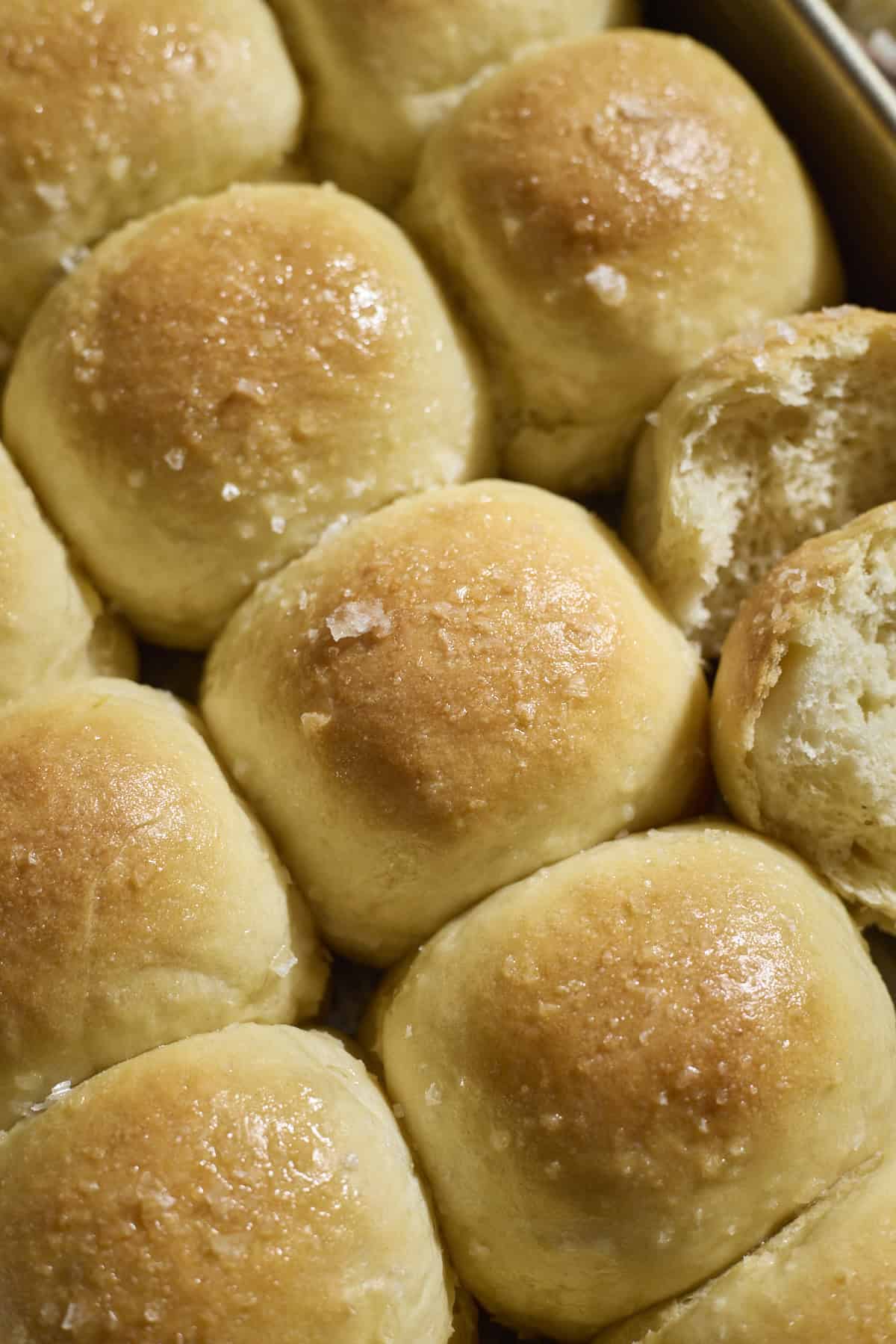 Sourdough Discard Potato Dinner Rolls topped with melted butter and flaky sea salt.