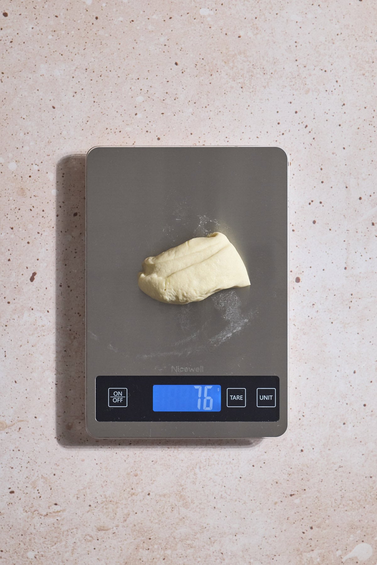 Dough being weighed on a kitchen scale.