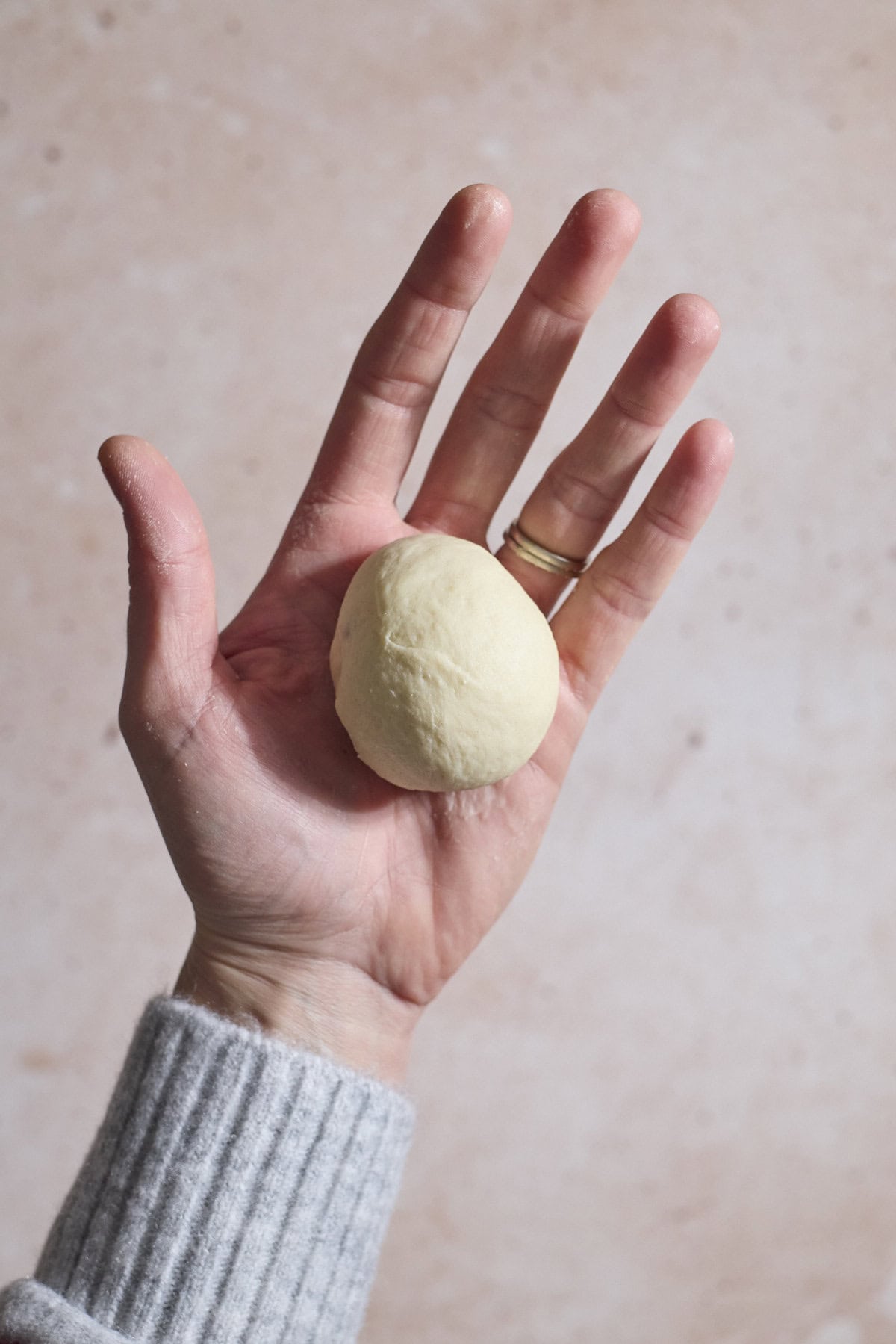 Dough shaped in the palm of a hand.