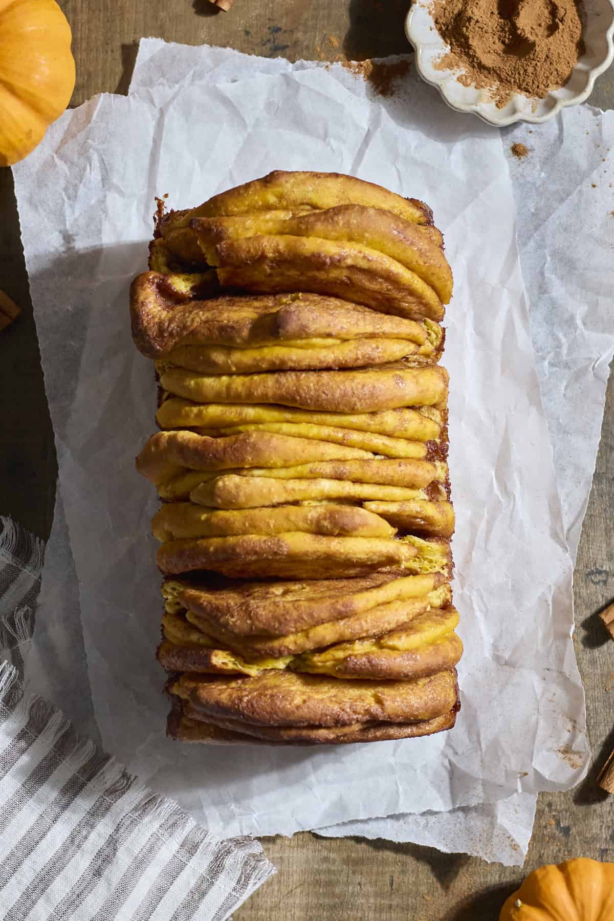 The baked pull apart bread on white parchment paper.