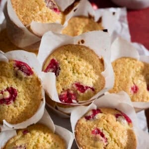 A pile of Sourdough Cranberry Orange Muffins on a tray.