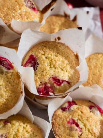 A pile of Sourdough Cranberry Orange Muffins on a tray.