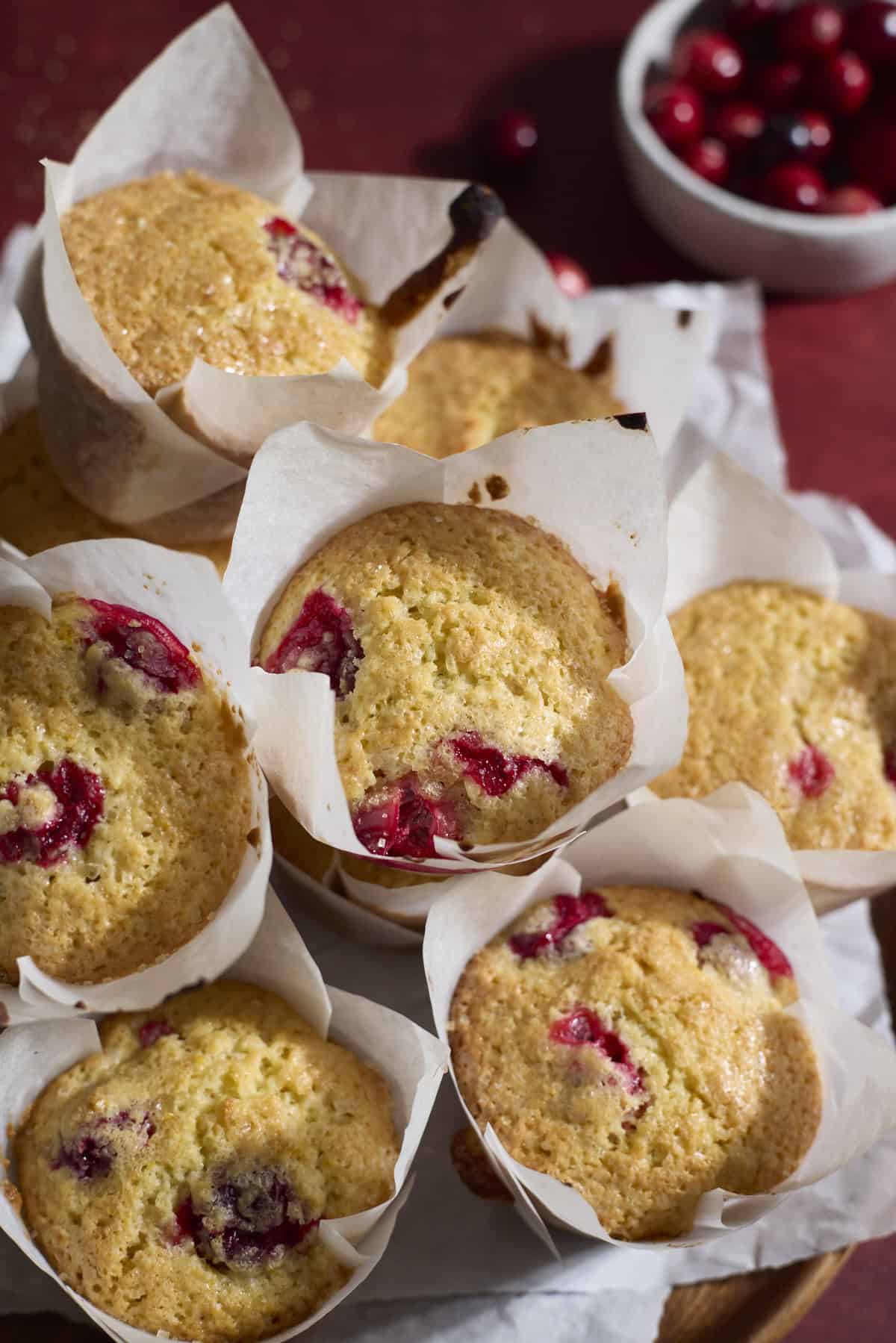 A pile of Sourdough Cranberry Orange Muffins on a tray.