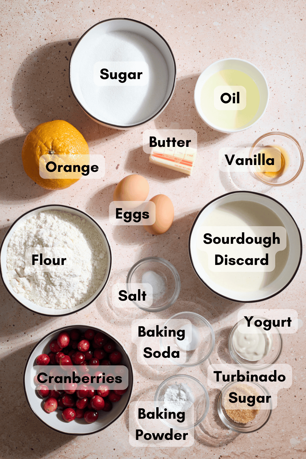 Ingredients for Sourdough Cranberry Orange Muffins in small bowls.