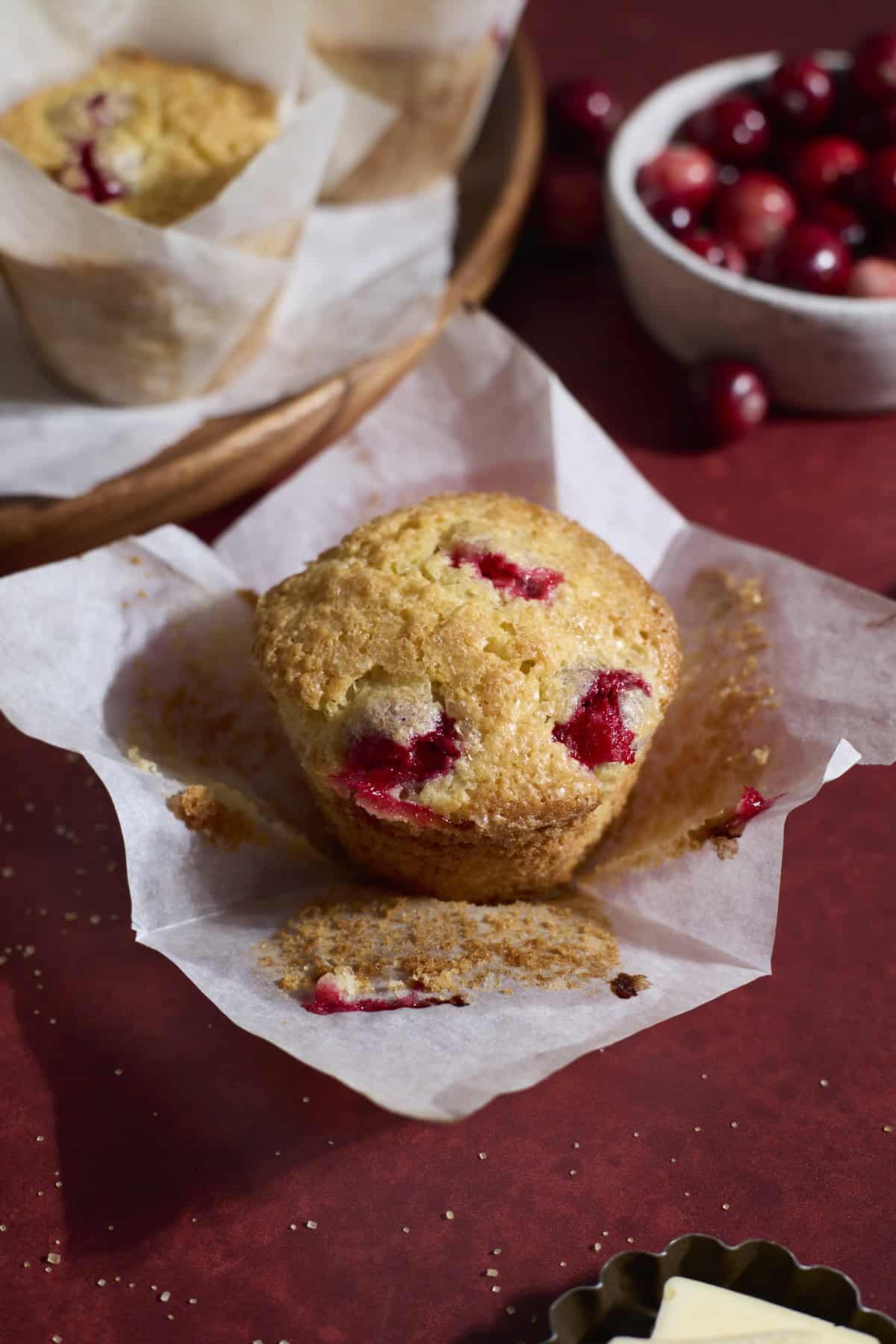 A Sourdough Cranberry Orange Muffin with the wrapper peeled back.