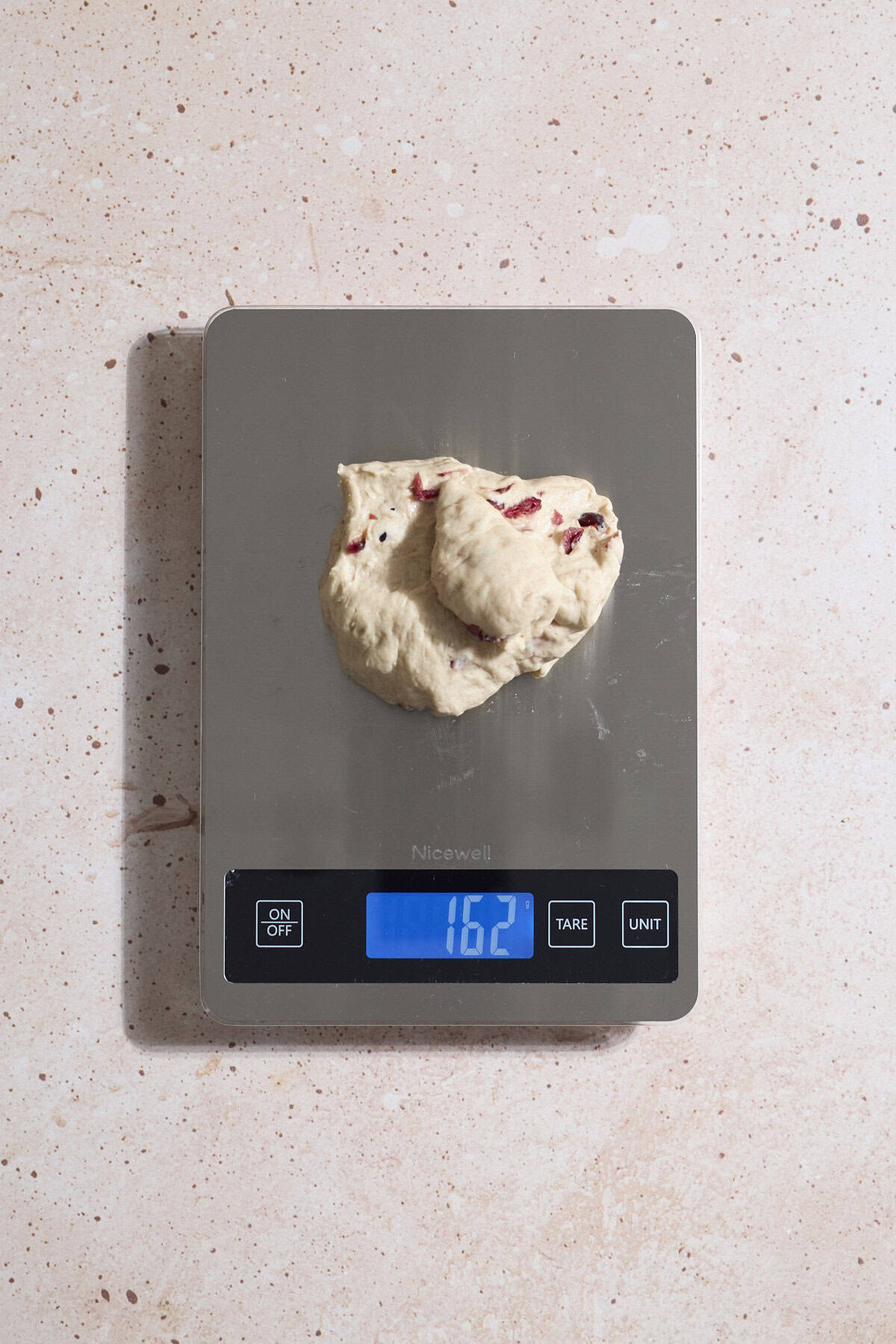 Dough being weighed on a kitchen scale.