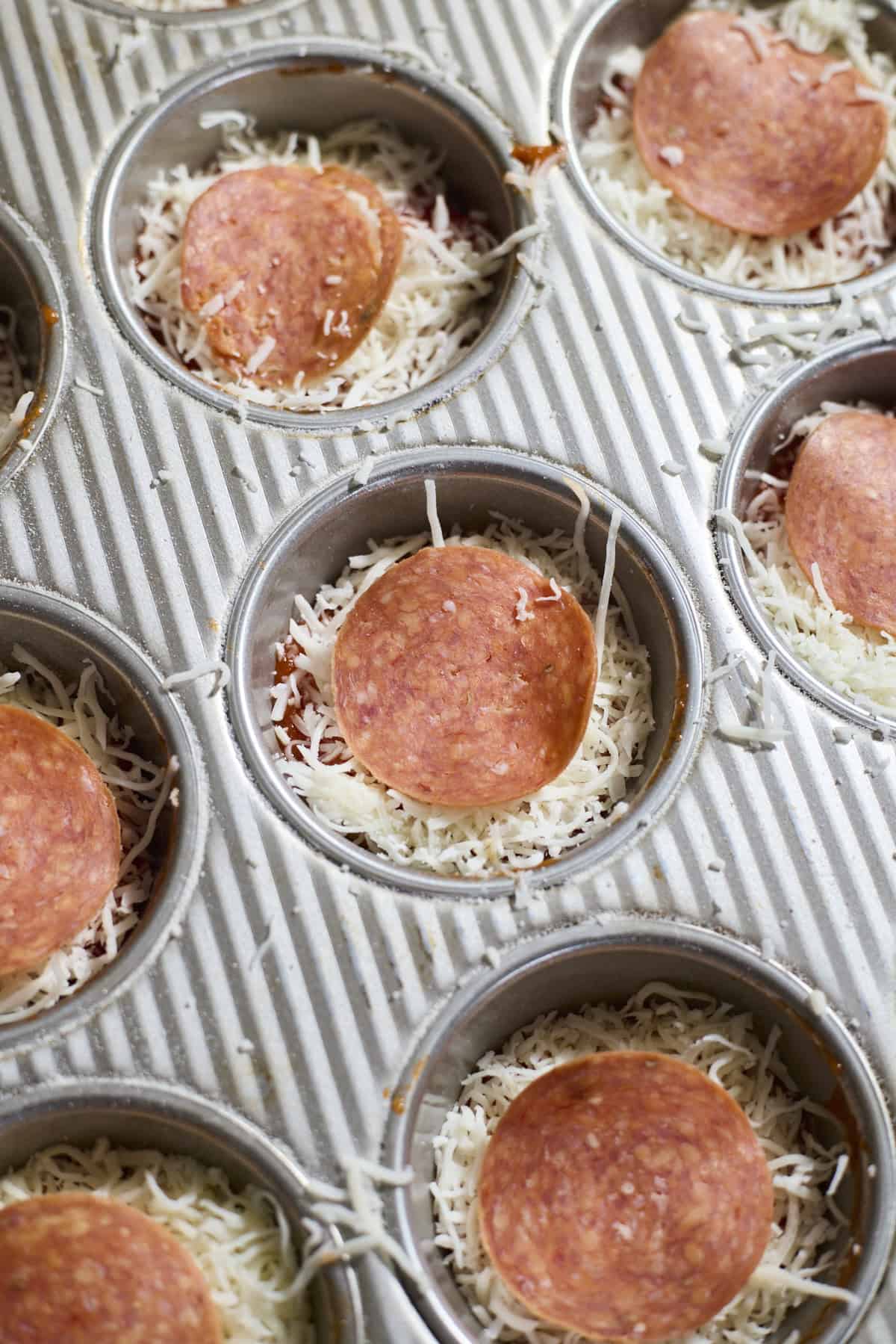 Miniature pizzas topped with pepperoni.