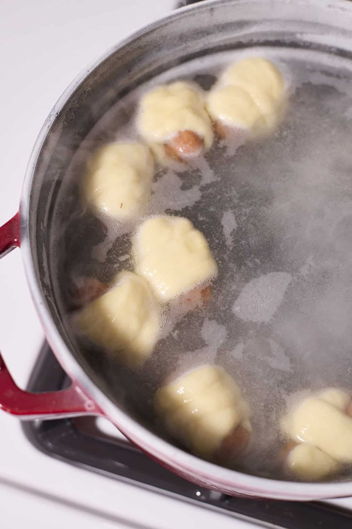 Pigs in a blanket floating in the boiling water.