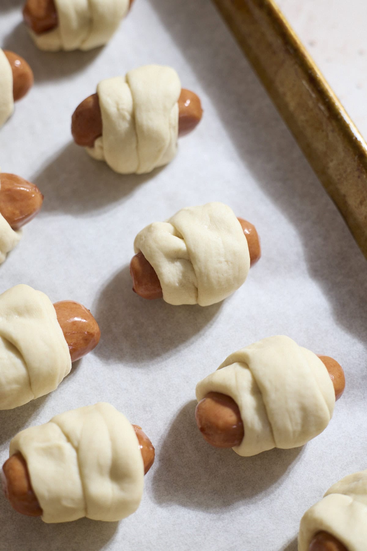 Dough wrapped around the cocktail sausages.