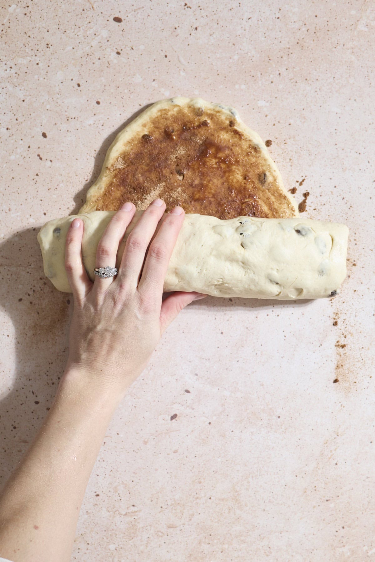 A hand rolling the dough.